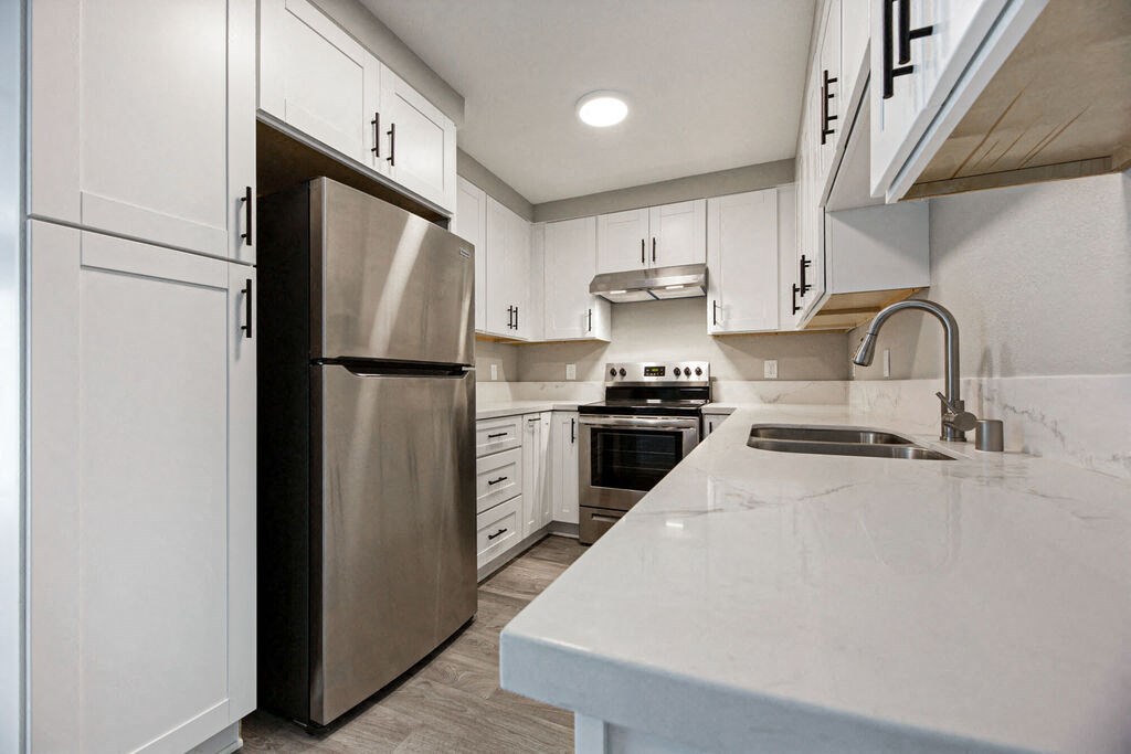 a large kitchen with white cabinets and stainless steel appliances at Citra Apartments LLC, California, 92107