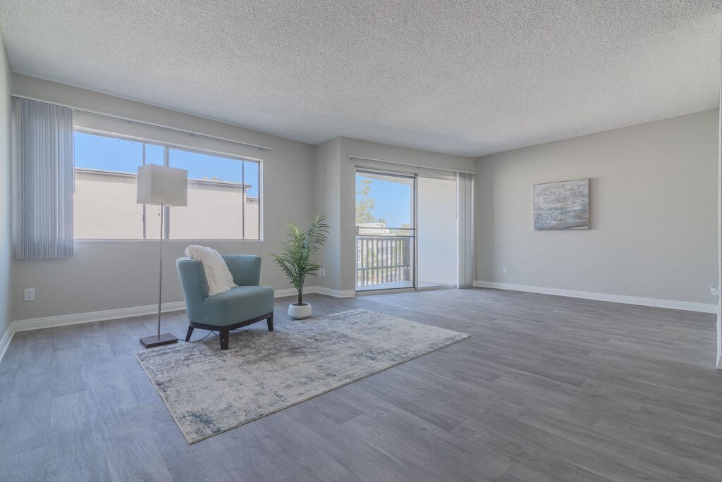 an empty living room with a chair and a rug at Citra Apartments LLC, San Diego