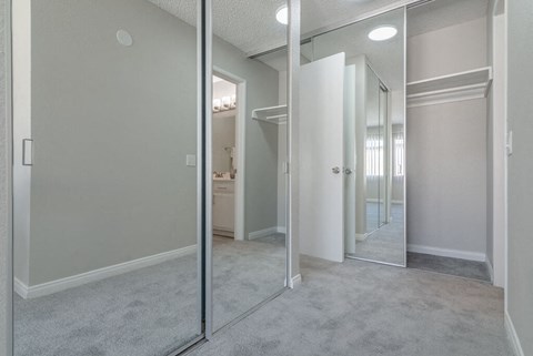 an empty bedroom with mirrored closet doors and a bathroom at Citra Apartments LLC, California, 92107