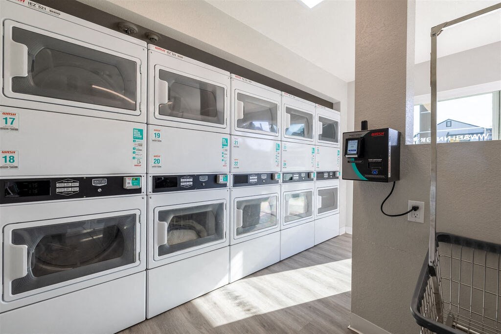 a row of laundry machines in a laundromat at The Gates at The Marina Apartments, Marina