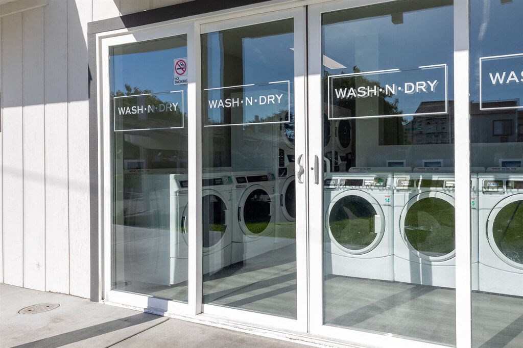 a row of washers and dryers in the window of a laundromat at The Gates at The Marina Apartments, Marina, 93933