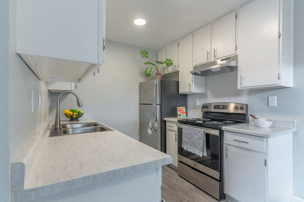 a white kitchen with stainless steel appliances and white cabinets at The Gates at The Marina Apartments, Marina, 93933