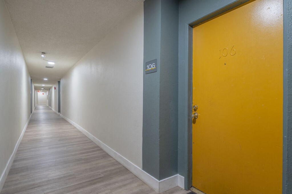 a hallway with a yellow door at the end of it at The Hills Apartments at Thousand Oaks, Thousand Oaks