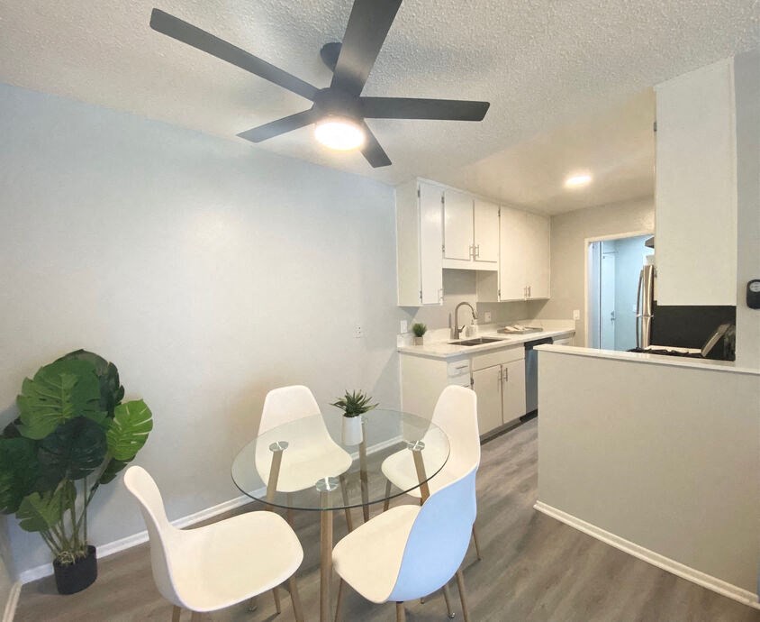a dining room with a glass table and chairs at The Hills Apartments at Thousand Oaks, Thousand Oaks, CA