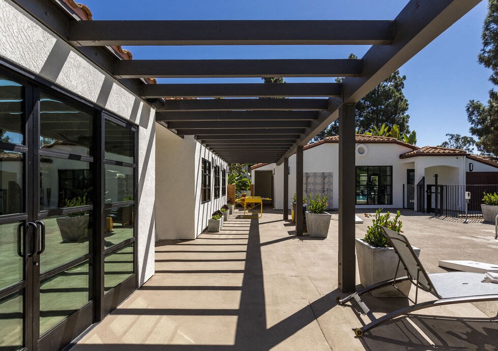a patio with chairs and awnings in front of a building at La Jolla Blue, California, 92122
