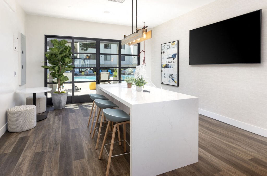 a kitchen with a long white counter top and a bar with stools at La Jolla Blue, San Diego, 92122