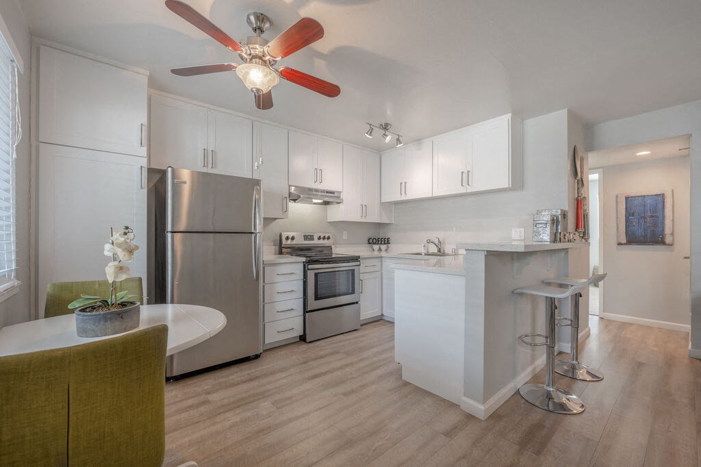 a kitchen with white cabinets and a ceiling fanat Napa Green Apartments LLC, Napa, 94559