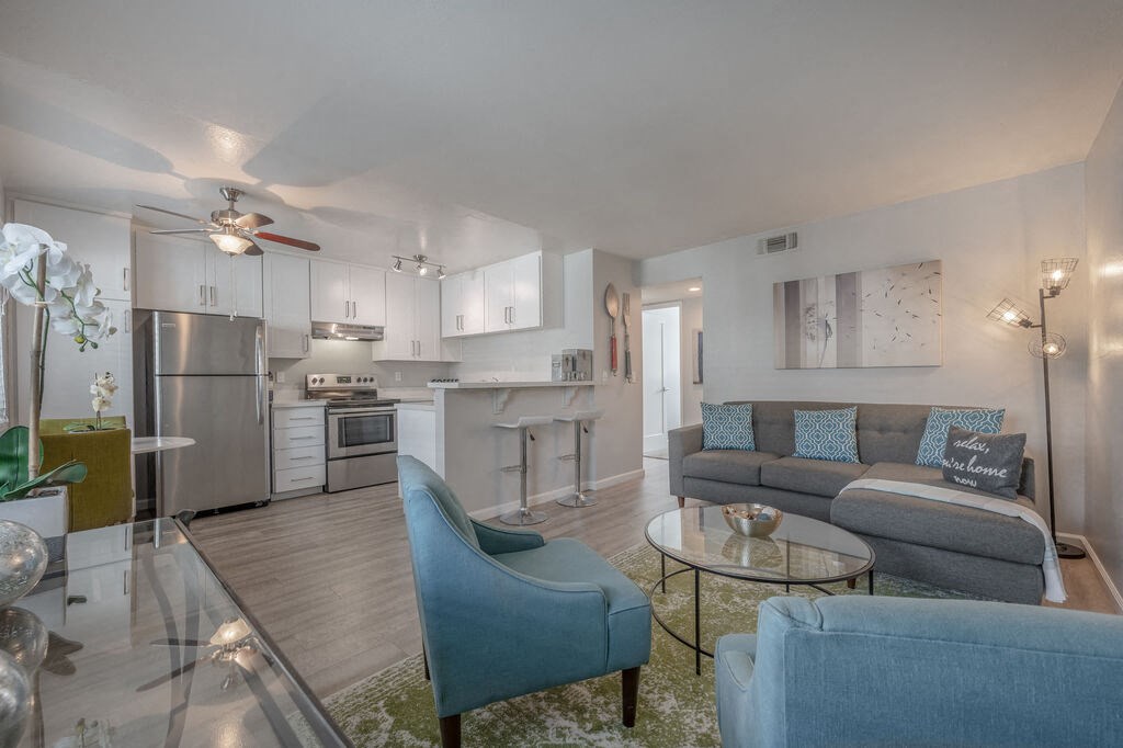 a living room with couches and chairs and a kitchen with stainless steel appliances at Napa Green Apartments LLC, Napa, 94559