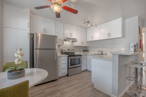 a kitchen with blue and red lights on the ceiling and white counters