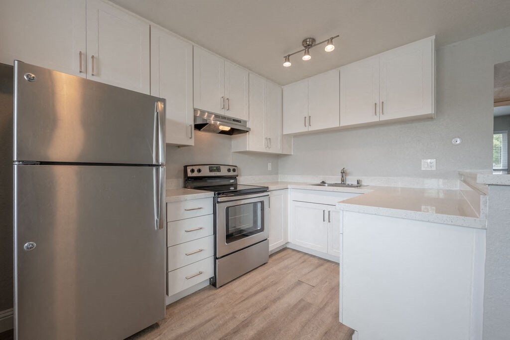 a kitchen with white cabinets and stainless steel appliances at Napa Green Apartments LLC, California