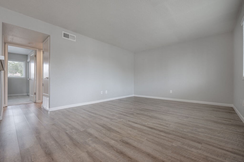 an empty living room with white walls and wood floors at Napa Green Apartments LLC, Napa California
