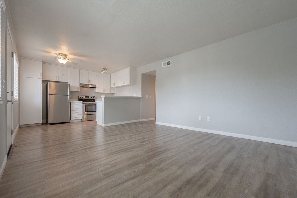 the living room and kitchen of an apartment with a wood floor at Napa Green Apartments LLC, California, 94559