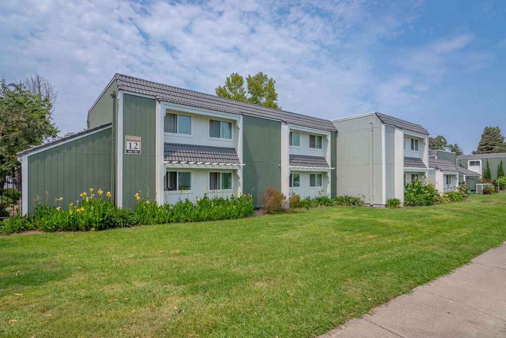 a row of green and white houses next to a sidewalk at Napa Green Apartments LLC, California, 94559