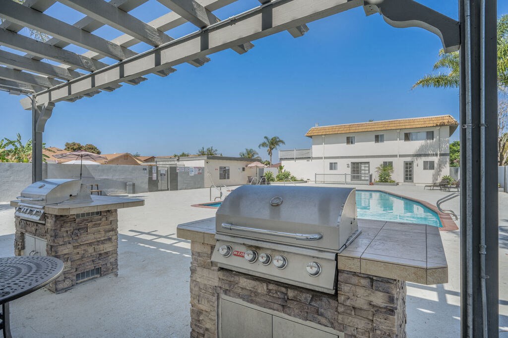 the property has an outdoor grill area with a pool at Ocean Villas, Oxnard, 93033
