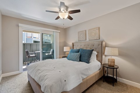 A bedroom with a large bed and a ceiling fan.
