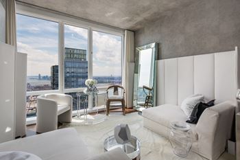 A modern bedroom with a large window overlooking the city. at SKY Apartments, New York, 10036