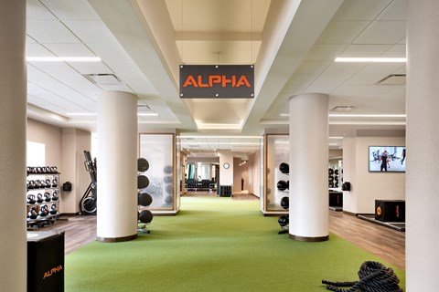 A gym with a green floor and a sign that says at One West, New York, New York