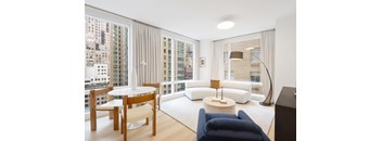 A living room with a white table and blue couch.