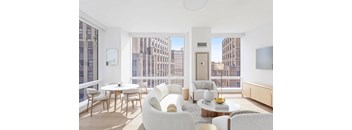 A living room with white furniture and a view of the city.