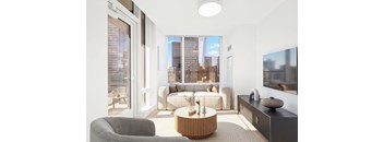 A modern living room with a grey sofa and a round wooden coffee table.