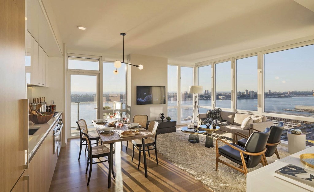 a rendering of a living room and dining room with a view of the water at SKY Apartments, New York, 10036