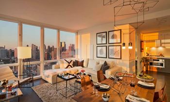 a living room filled with furniture and a large window at SKY Apartments, New York, NY, 10036