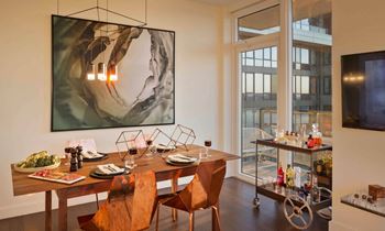 a dining room with a table and chairs and a painting on the wall at SKY Apartments, New York, New York