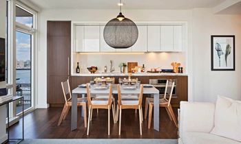 a dining room and kitchen with a wooden table and chairs at SKY Apartments, New York