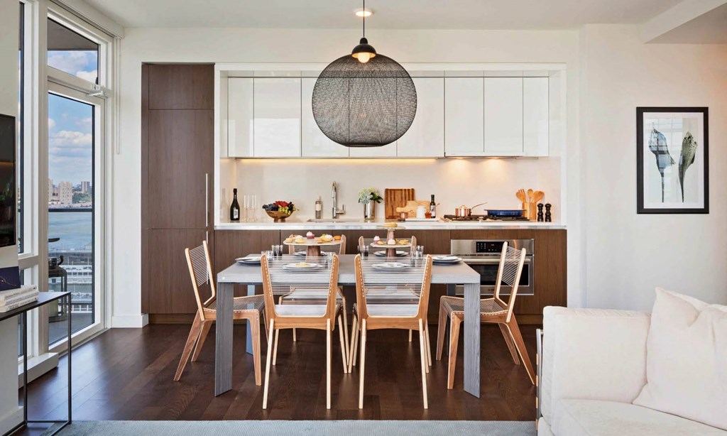 a dining room and kitchen with a wooden table and chairs at SKY Apartments, New York