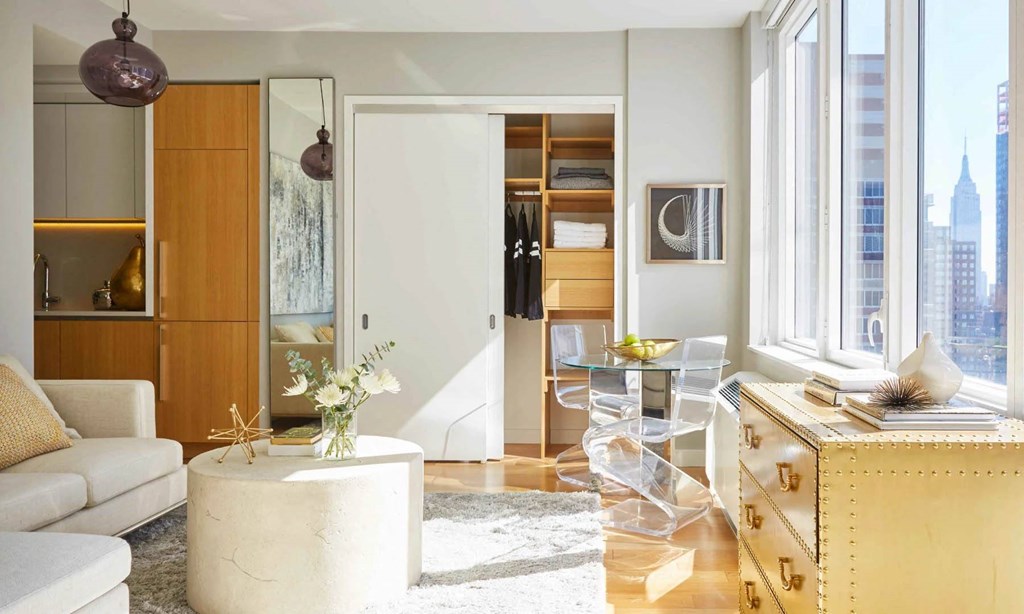 a living room filled with furniture and a large window at SKY Apartments, New York, New York