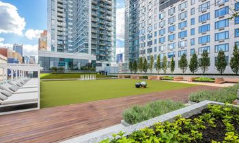 a rendering of a rooftop terrace with a lawn and buildings in the background at SKY Apartments, New York, New York