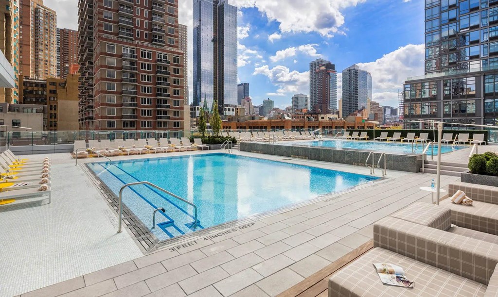 the pool on the rooftop of a building with a city in the background at SKY Apartments, New York, New York