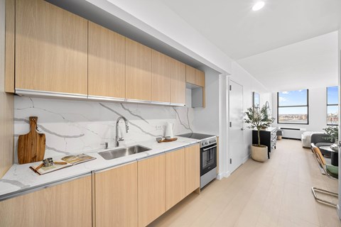A modern kitchen with wooden cabinets and a marble countertop.