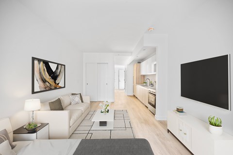 A modern living room with a large painting on the wall and a flat screen TV mounted above a cabinet.