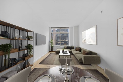 A modern living room with a long couch and a table in the middle.