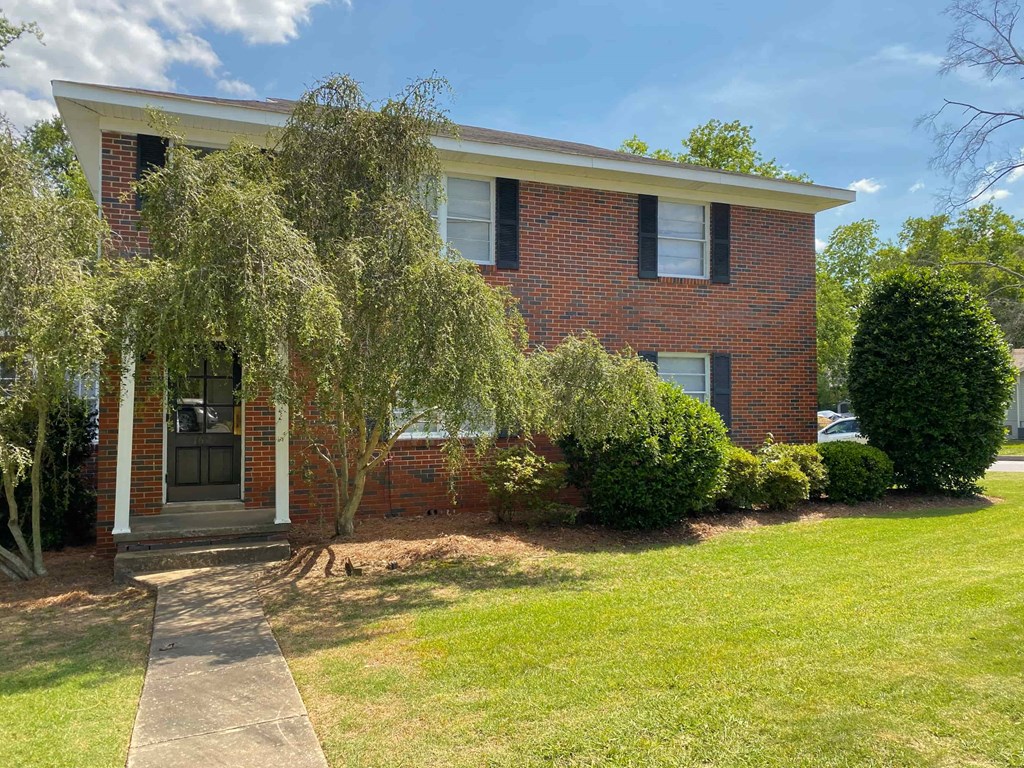 a brick house with a tree in front of it