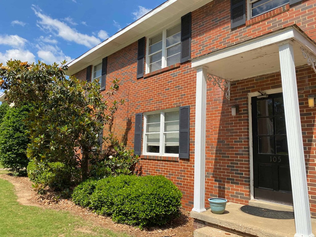 the front of a brick house with a black door