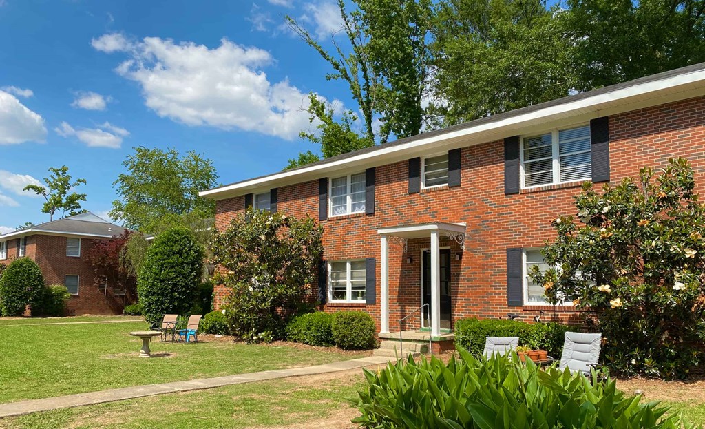 a red brick house with a lawn in front of it