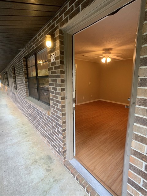 a view of a living room from the patio of a brick house