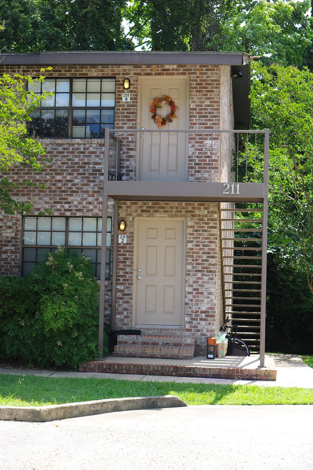 the front of a brick house with a white door and a wreath