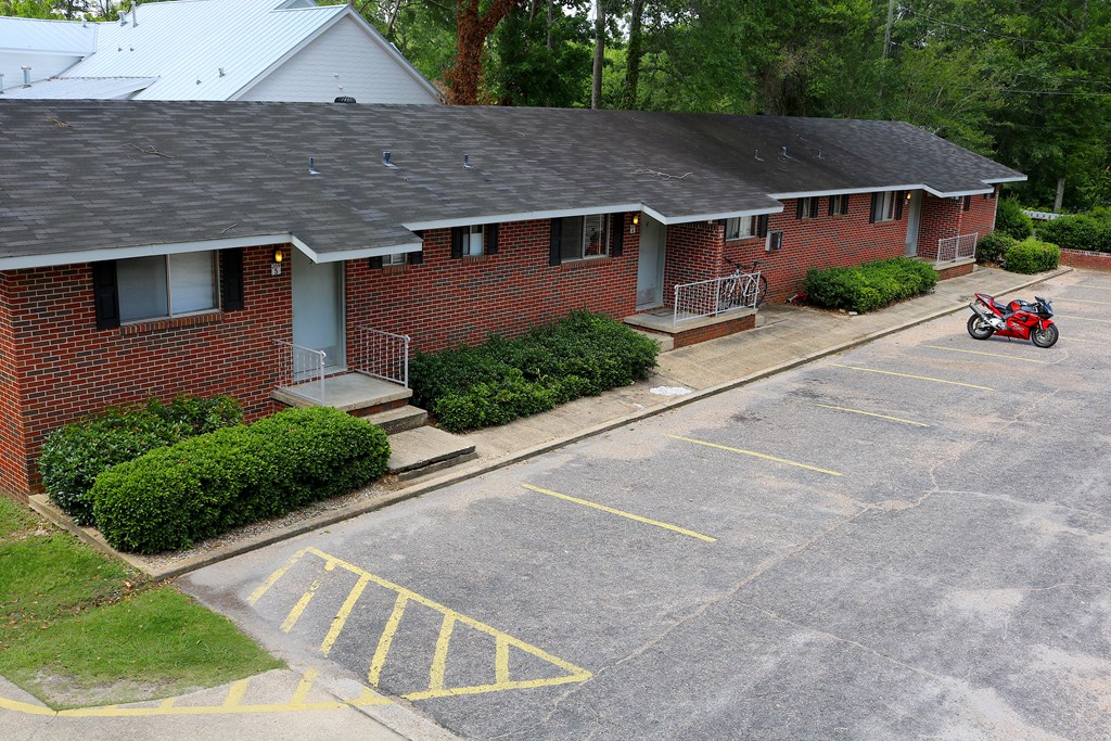 an aerial view of a brick house with a motor scooter parked in the driveway