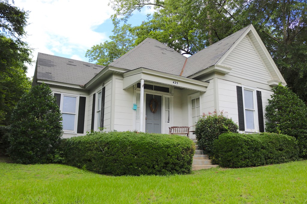 a white house with a bench in front of it