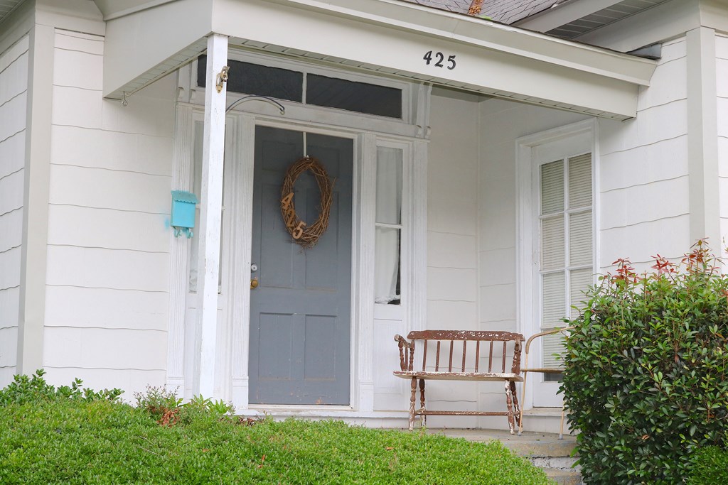 a front porch with a bench and a blue door