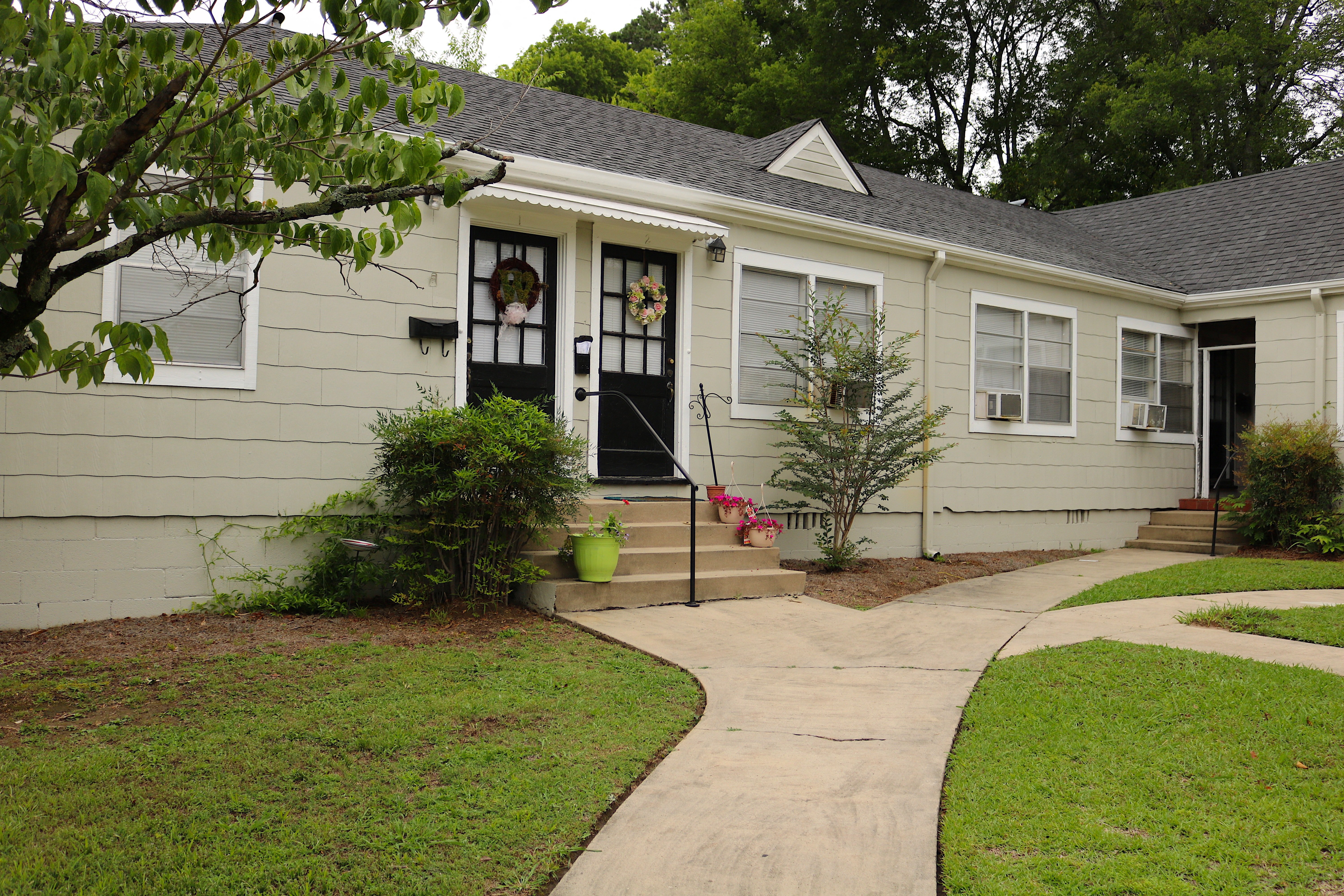 the front of a house with a sidewalk in front of it