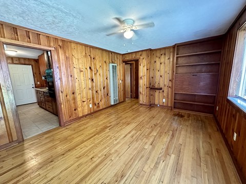a living room with wood floors and a ceiling fan