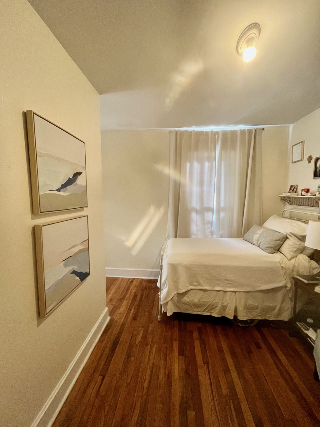 a bedroom with a bed and a painting on the wall