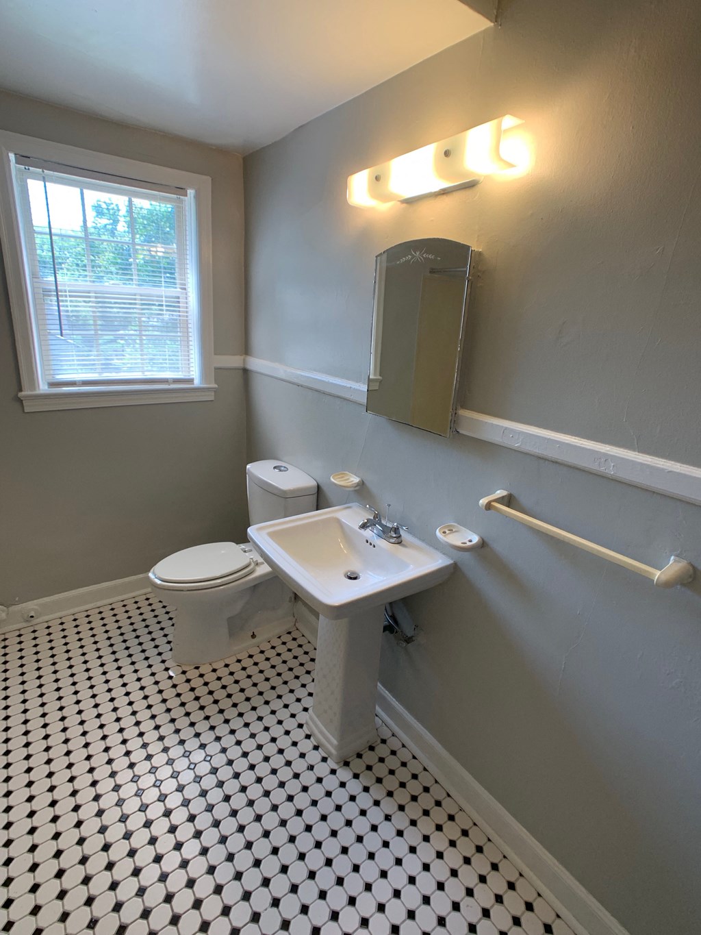 a bathroom with a toilet and a sink and a window