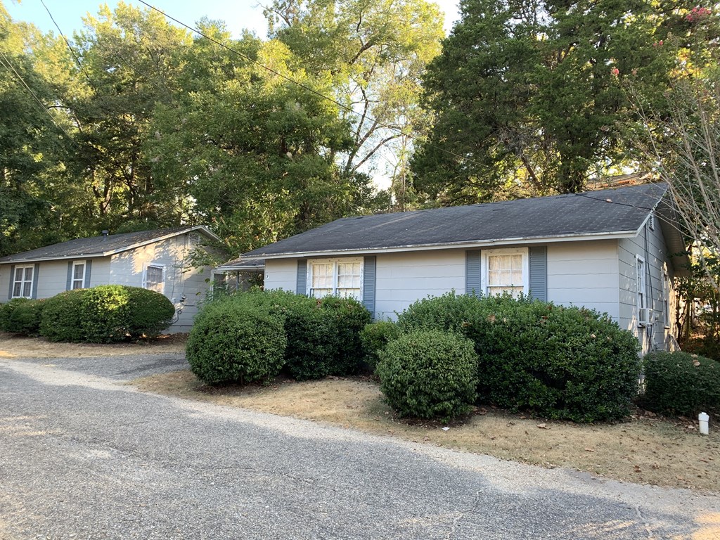 a blue and white house with bushes in front of it