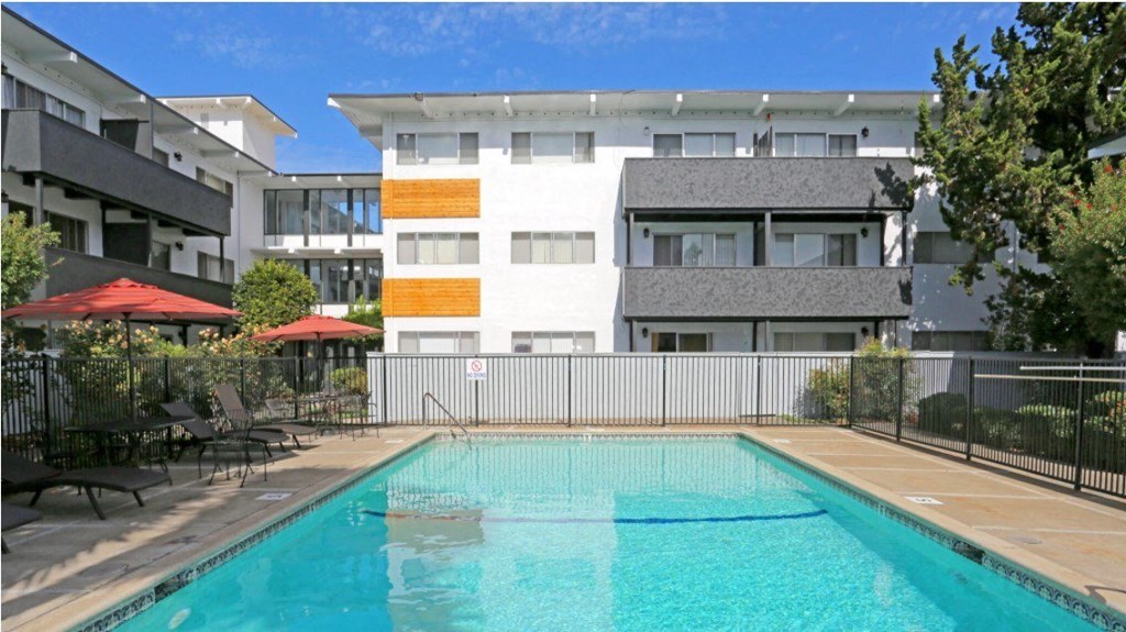 3 stories white building and pool