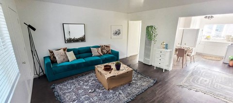 A living room with a blue couch and a wooden coffee table.